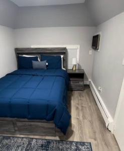 a bedroom with a blue bed and a desk at Cozy Studio with 1 Bed & Comfy Sofa Bed in New Rochelle +7 photos