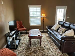 a living room with a leather couch and a coffee table at Five Stars Luxury Home in Clarksville
