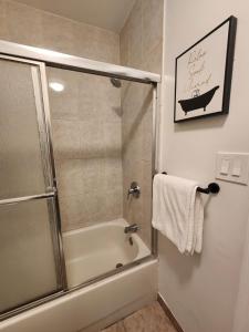 uma casa de banho com uma banheira e um chuveiro com uma porta de vidro em Casita En Miami em Miami