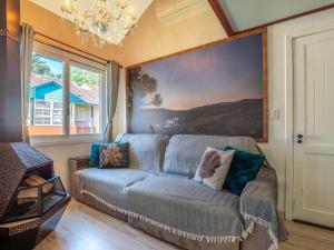 una sala de estar con sofá y una pintura en la pared en Belíssimo Duplex a 500m Lago Neg 3Q 4bikes Churrasq lareira Ar QF, en Gramado
