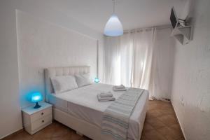 sypialnia z białym łóżkiem i niebieską lampką w obiekcie Seaview Rooms w mieście Vasiliki +6 zdjęć