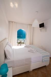 1 dormitorio con cama y vistas al océano en Seaview Rooms, en Vasiliki
