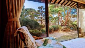 um quarto com uma janela com vista para um jardim em 富士吉田かつまたや em Fujiyoshida