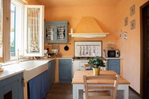 PiazzaにあるTerra Sole Aria Home Bresciaのキッチン(青いキャビネット、木製テーブル付)