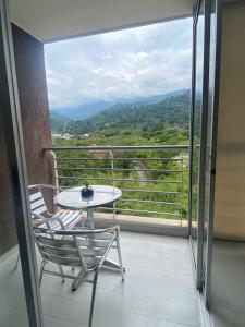 a balcony with a table and chairs and a view at Lujoso apartamento piscina\gym in Floridablanca
