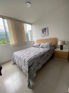 a bedroom with a bed in a room with windows at Lujoso apartamento piscina\gym in Floridablanca