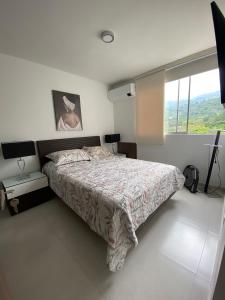 a bedroom with a bed and a large window at Lujoso apartamento piscina\gym in Floridablanca
