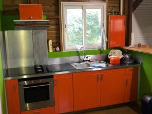 a kitchen with orange cabinets and a sink and a window at MAISON FAMILLE RANCE in Pointe-Noire
