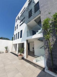 an exterior view of a white building with plants at FIESTA MIRAMAR in Ciudad Madero