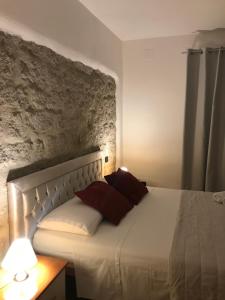 a bedroom with a white bed with two red pillows at Monis Hogar in Arzachena