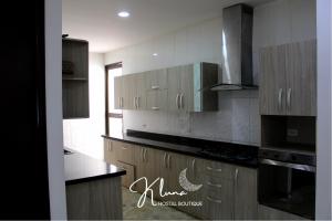 a kitchen with wooden cabinets and black counter tops at K Luna Hostal Boutique in Ríohacha