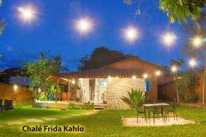une maison avec une table dans la cour la nuit dans l'établissement Casa de Frida Pousada Galeria, à Pirenópolis