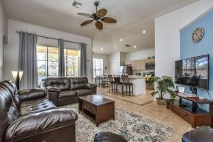 a living room with leather couches and a kitchen at Pool Home in Famous Windsor Palms Resort 4 Miles to Disney, Free Resort Amenities in Kissimmee