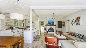 a kitchen and living room with a couch and a table at Tea Tree House - Pearl Beach in Pearl Beach
