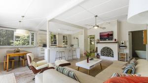 a living room with a couch and a fireplace at Tea Tree House - Pearl Beach in Pearl Beach