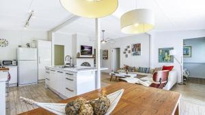 a kitchen and a living room with a table at Tea Tree House - Pearl Beach in Pearl Beach