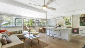 a kitchen and living room with a couch and a table at Tea Tree House - Pearl Beach in Pearl Beach +7 photos
