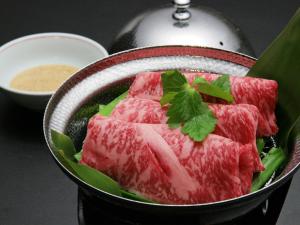a bowl filled with meat and a bowl of dipping sauce at Hyoe Koyokaku in Kobe