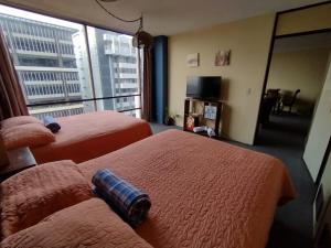 a hotel room with two beds and a large window at Apartamento 1007 Cortijo Reforma zona 9 in Guatemala