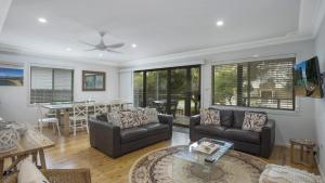 a living room with a couch and a table at Pippi Rikki - Pearl Beach With Wifi in Pearl Beach