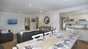 a living room with a table and a couch at Pippi Rikki - Pearl Beach With Wifi in Pearl Beach