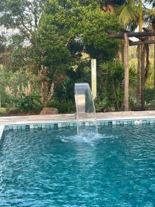 una fuente en medio de una piscina en Pousada Rural Ouro Verde en Eldorado