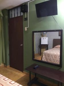 espejo en una habitación con cama y mesa en Linda habitación de hotel en Trujillo, en Palomar
