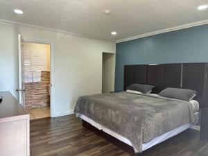 a bedroom with a large bed and a bathroom at Bartlett Motel in Lomita