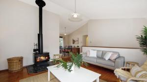 a living room with a couch and a wood stove at Hidden Treasure - Family Friendly Holiday Home in Pearl Beach