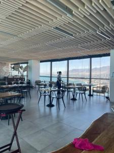 a person sitting at a table in a restaurant with tables and chairs at Antofagasta de Lujo in Antofagasta