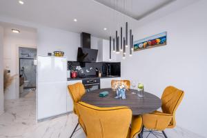 a kitchen with a dining room table and chairs at Blue Ivy in Mlini