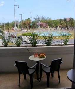 een tafel en stoelen in een kamer met uitzicht op een straat bij BOK21 - Hotel en Cancun in Cancun