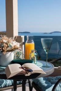 米利尼的住宿－Blue Ivy，一张桌子,上面放着一本书和一杯橙汁
