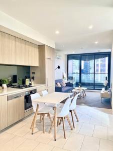 メルボルンにあるStunning 2-Bed Apartment with Panoramic CBD Viewsのテーブルと椅子のあるキッチンとリビングルーム