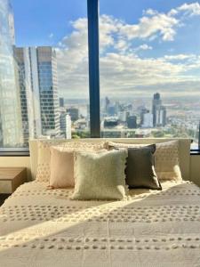 メルボルンにあるStunning 2-Bed Apartment with Panoramic CBD Viewsの大きな窓のある部屋のベッド