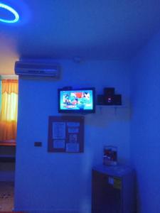 Cette chambre bleue dispose d'une télévision sur un mur bleu. dans l'établissement Hotel Nogales Riohacha, à Ríohacha
