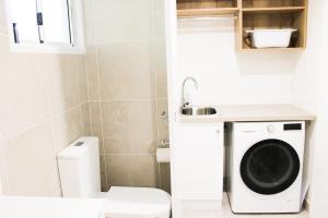 a small bathroom with a washing machine in it at Shingley Beach Resort - Whitsundays in Airlie Beach