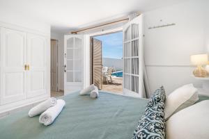 a bedroom with a bed and a view of the ocean at Can Poriol in Alaior