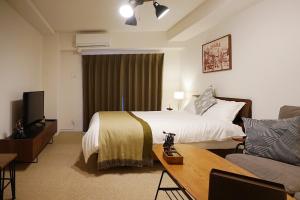 um quarto de hotel com uma cama e um sofá em 川House難波南-花园町 em Osaka