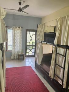 um quarto com um beliche e um tapete vermelho em Hobo Hostel em Dharamshala