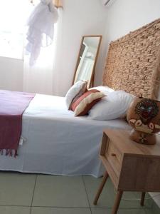 a bedroom with a bed with a mirror and a table at Dous'Inn Kreyol Appartement in Grand-Bourg