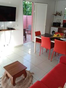a living room with a red couch and a table at Dous'Inn Kreyol Appartement in Grand-Bourg