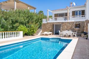 uma villa com piscina em frente a uma casa em Can Poriol em Alaior