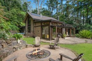 a house with a fire pit in the yard at Lyra Kangaroo Valley in Kangaroo Valley