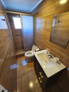 uma casa de banho com um WC, um lavatório e um chuveiro em Casa blanca bella vista em Tongoy