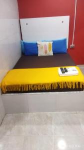 a bed in a room with a yellow blanket on it at Hotel la Sierra Riohacha I in Ríohacha