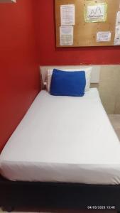 a bed with a blue pillow on top of it at Hotel la Sierra Riohacha I in Ríohacha