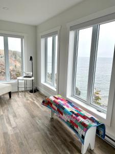 ein Schlafzimmer mit Fenstern und ein Bett mit einer bunten Decke in der Unterkunft The View suites and breakfast in Triton, Newfoundland in Pilleyʼs Island