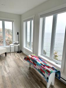 a bedroom with windows and a bed with a colorful blanket at The View suites and breakfast in Triton, Newfoundland in Pilleyʼs Island