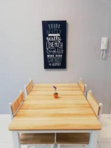 コタキナバルにあるBlue Sky Apartment at Sutera Avenue 5-6 PAXの壁に看板が掛かっている部屋の中の木製のテーブル